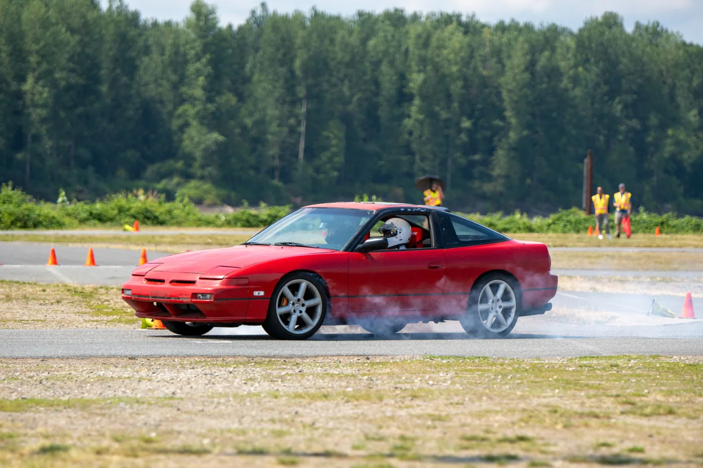 Nathan driving a red coupe sideways at autocross, tires smoking
