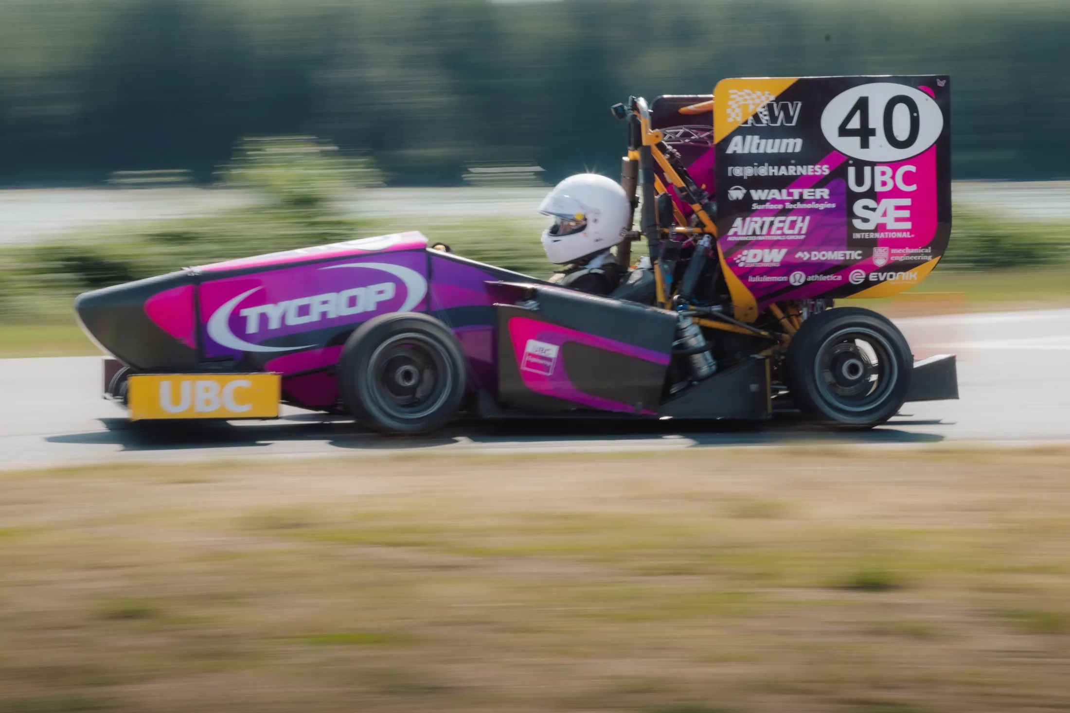 Nathan driving Formula UBC's pink 2026 car, number 40, past the camera at speed